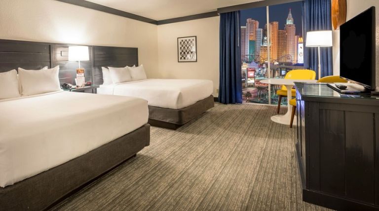 Two queen bed next to window with Strip view