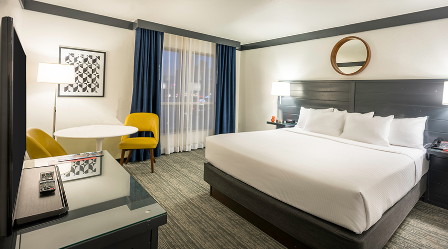 One king bed next to window with airport view.